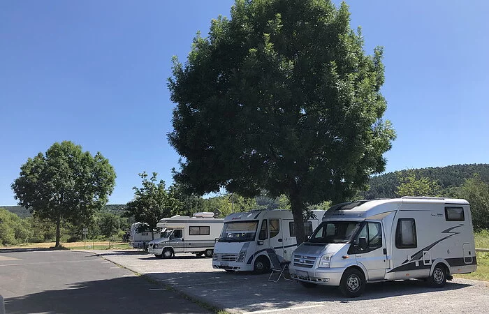 Wohnmobile auf gepflasterten Stellplätzen. Umgeben mit Wiesen und Bäumen
