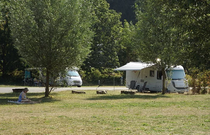 Wiese mit Bäumen und zwei Wohnmobilen