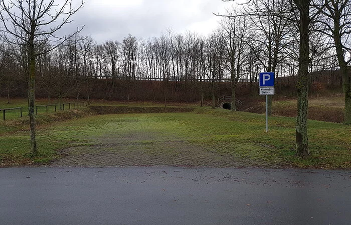 Grünfläche mit Bäumen im Hintergrund