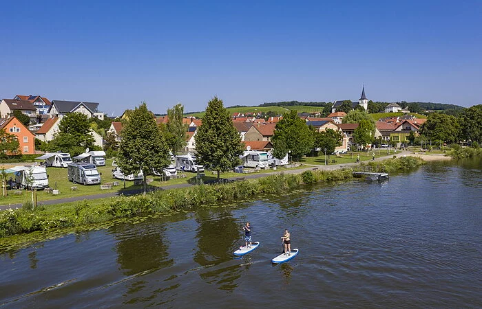 Wohnmobilstellplatz am Main, mit Häusern im Hintergrund
