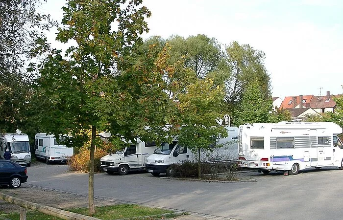 Wohnmobile auf gepflasterten Stellplätzen mit Bäumen