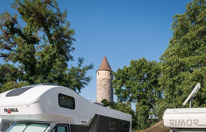 Wohnmobildach mit einem Turm der Stadtmauer im Hintergrund