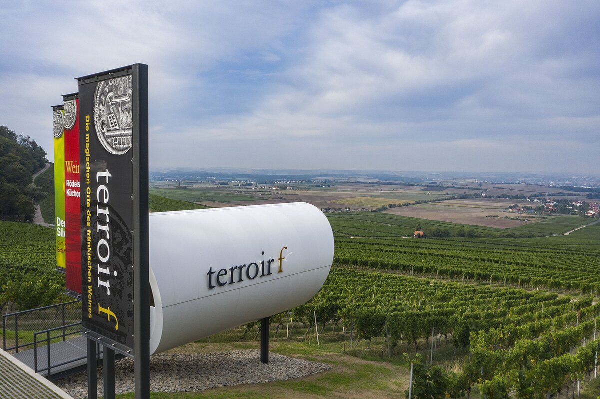 Aussichtspunkt mit einer begehbaren Röhre und Fahnen inmitten der Weinberge