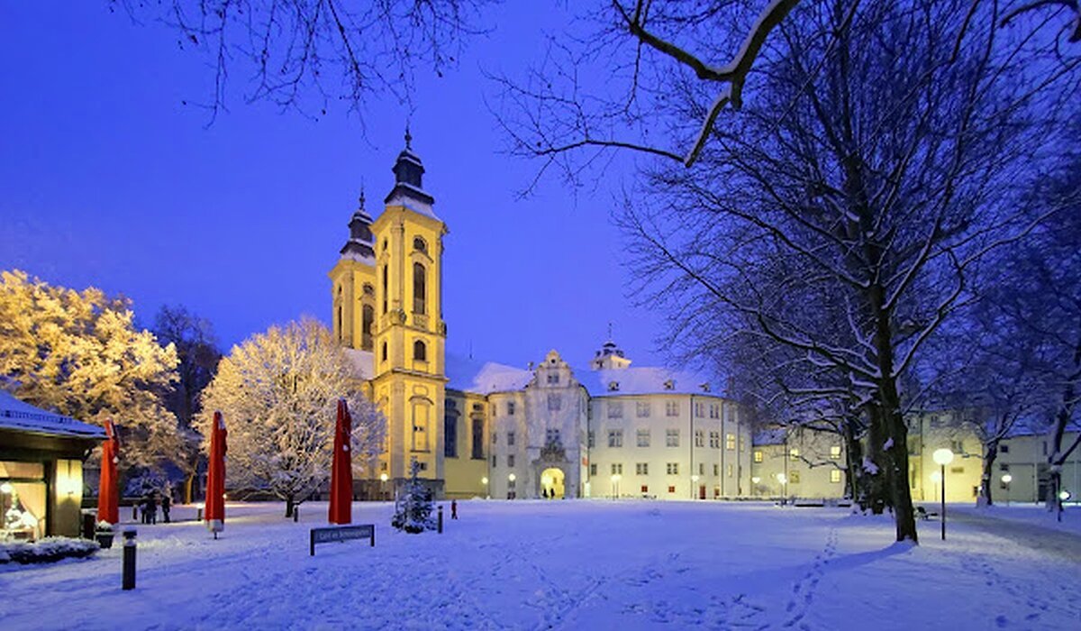 Schneebedeckter Platz mit einem Schloss im Hintergrund