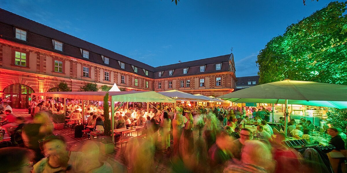 Bunt iluminiertes Bürgerspital Hofenschoppenfest mit Gästen im Innenhof des Bürgerspitals
